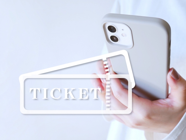 スマホを手に持っているイメージ画像。チケットのテキスト文字あり。