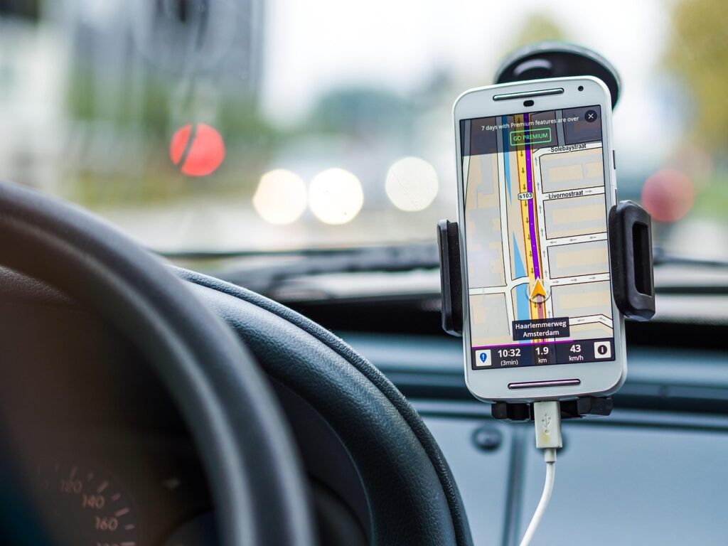 スマホの地図を確認しながら車を走らせているイメージ画像